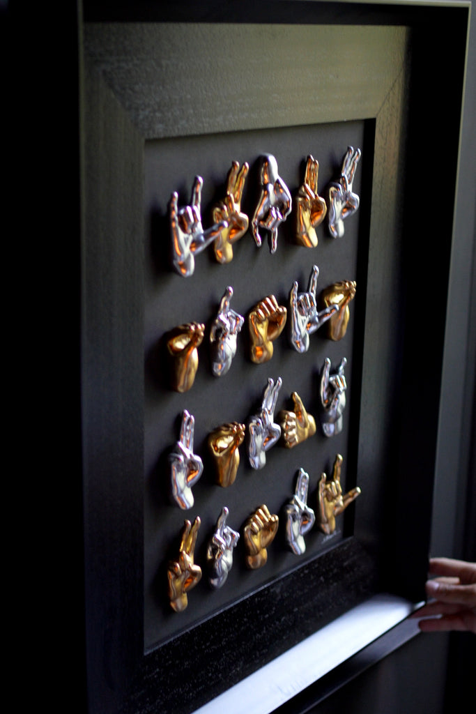 Multimani - sculptures in shiny silver and gold resin on a black background frame with an Italian handcrafted frame