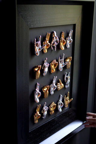 Multimani - sculptures in shiny silver and gold resin on a black background frame with an Italian handcrafted frame
